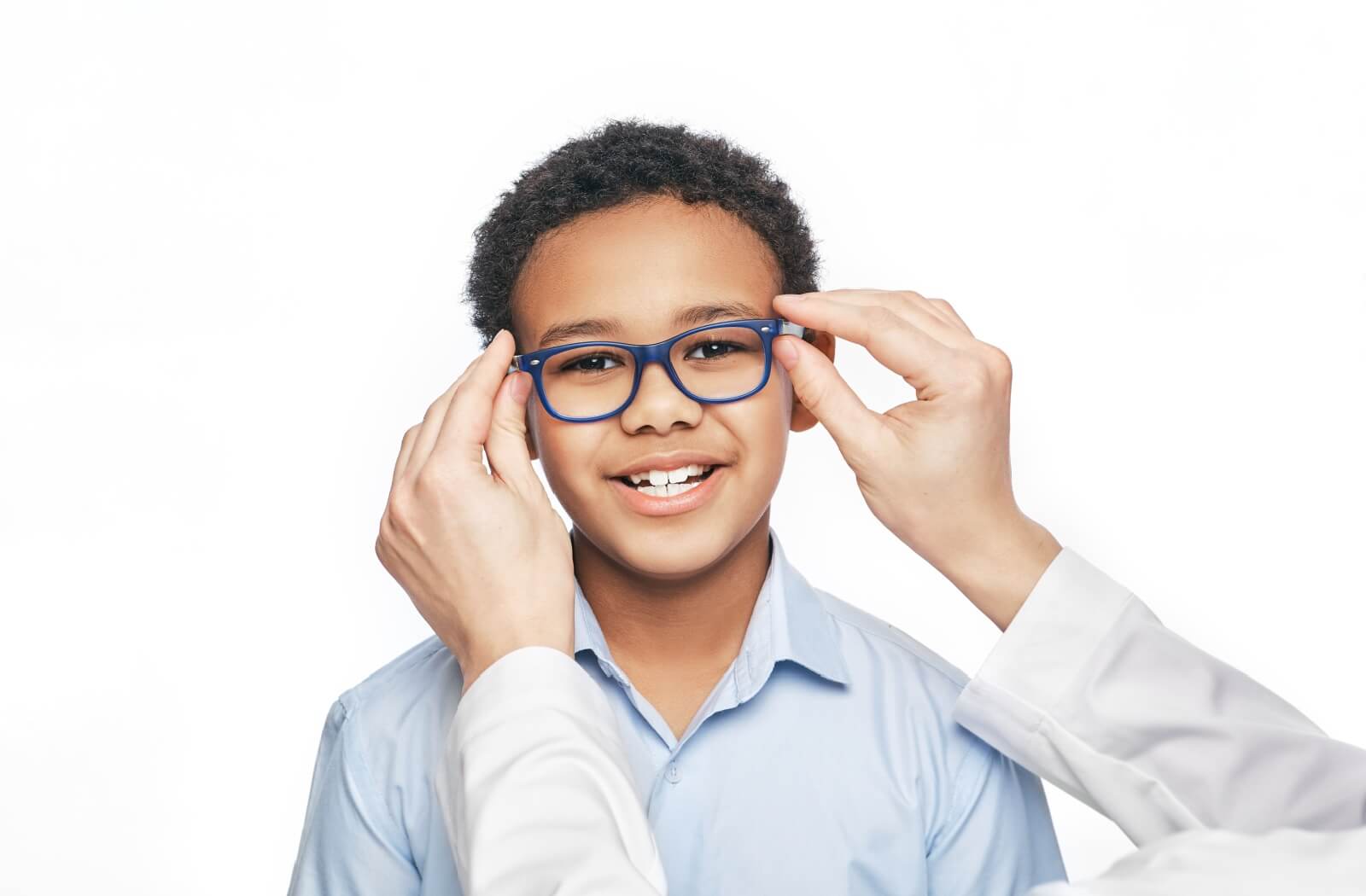 A child smiling while an optometrist fits them with a pair of myopia control glasses.