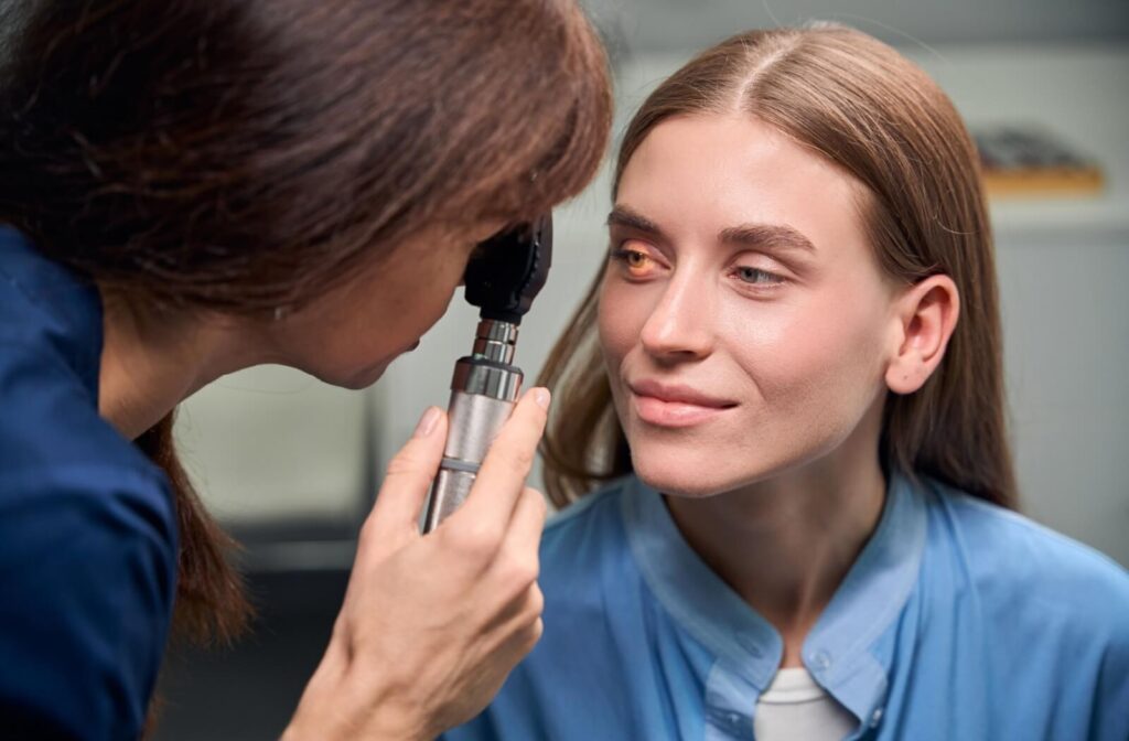 An optometrist shines a light into their patient's eyes during an eye exam to check their patient's eye health.