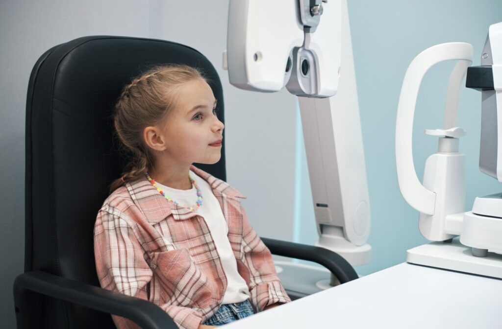 A young child getting ready for their eye exam at the eye doctor's
